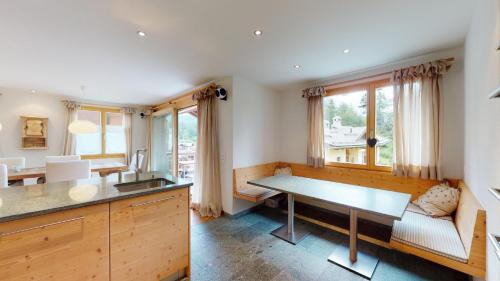 a kitchen with a desk and a table in a room at Abitaziun Blaunca - Maloja in Maloja