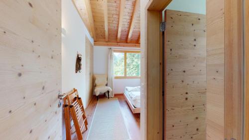 a room with a wooden wall and a bedroom at Abitaziun Blaunca - Maloja in Maloja