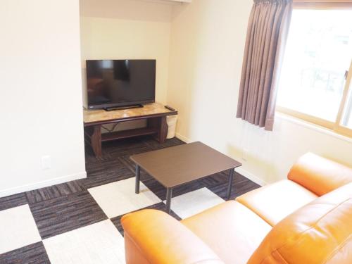 a living room with a couch and a television at Harbour Inn & Suites - Vacation STAY 8829 in Niigata