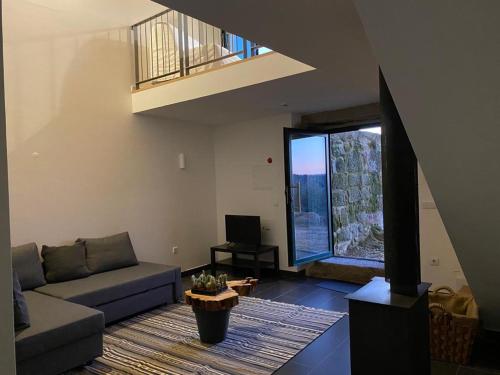 a living room with a couch and a large window at Quinta Casa do Retiro in Penalva do Castelo