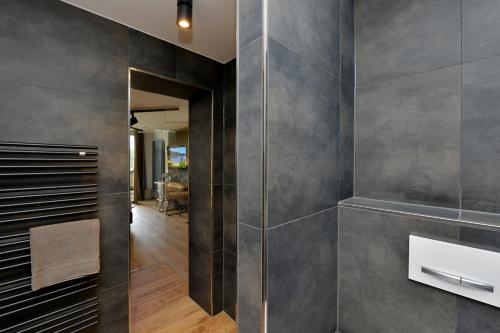 a bathroom with gray walls and a walk in closet at Pension Waldkristall in Frauenau