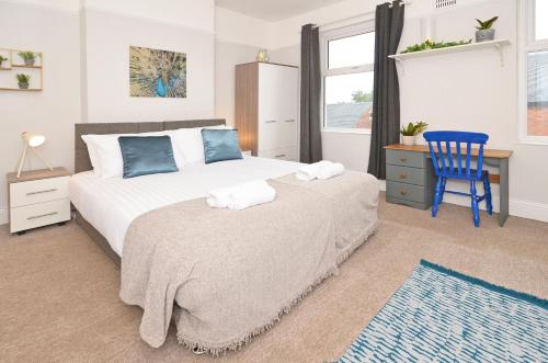 1 dormitorio con 1 cama y 1 silla azul en Venture House by YourStays, en Stoke on Trent