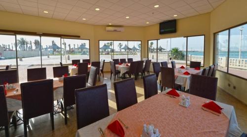 een restaurant met tafels en stoelen en uitzicht op de oceaan bij لافونتين البحيرة in Al Khobar