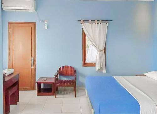 Dieses blaue Zimmer verfügt über einen Schreibtisch, einen Stuhl und ein Fenster. in der Unterkunft RedDoorz near Pantai Citepus Pelabuhan Ratu in Sukabumi