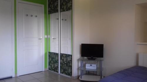 une chambre avec un lit, une télévision et un miroir dans l'établissement Le Petit St Clair, au Puy-en-Velay