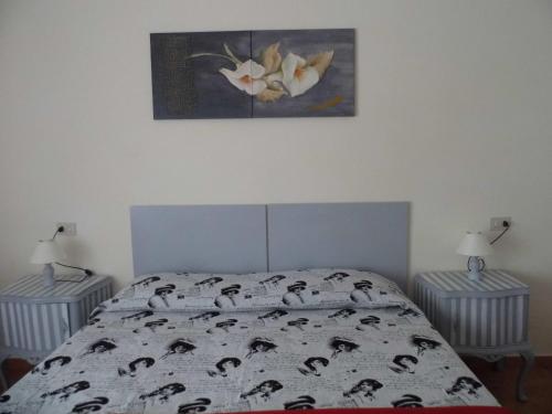 a bedroom with a bed and a painting on the wall at Lina Hotel in Stintino