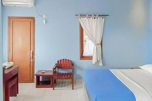 Habitación azul con cama, silla y ventana en RedDoorz near Pantai Citepus Pelabuhan Ratu, en Sukabumi
