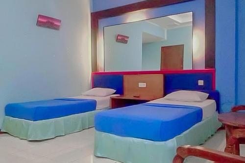 2 camas en una habitación con espejo en RedDoorz near Pantai Citepus Pelabuhan Ratu, en Sukabumi