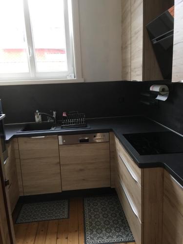 eine Küche mit einer schwarzen Arbeitsplatte und einem Waschbecken in der Unterkunft Sans Adieu in Wimereux