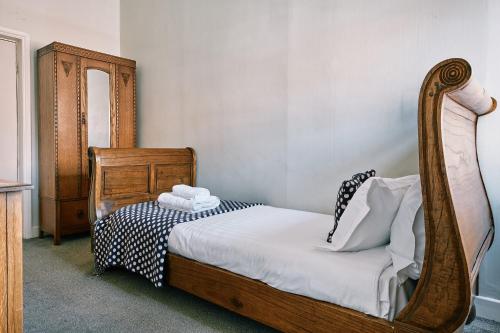 a bedroom with a wooden bed and a mirror at The Queens Hotel in Lytham St Annes