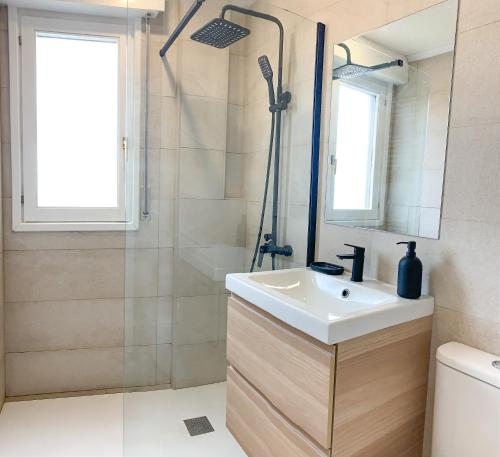 y baño con lavabo y ducha. en ACOGEDOR APARTAMENTO CON TERRAZA Y PARKING Publico EN COMILLAS, en Comillas