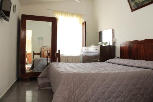 - une chambre avec un grand lit et un miroir dans l'établissement Casa Normanna, à Acerenza