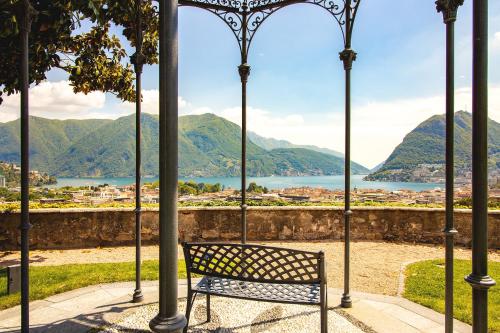 a bench sitting on avisor with a view of the water at Villa Sassa in Lugano
