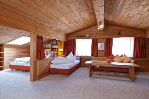 Habitación con 2 camas, sofá y mesa. en Hotel Toni, en Galtür