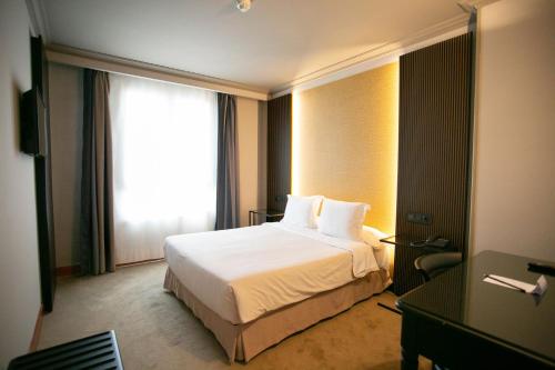 a hotel room with a bed and a window at Hotel Sercotel Ciudad de Oviedo in Oviedo
