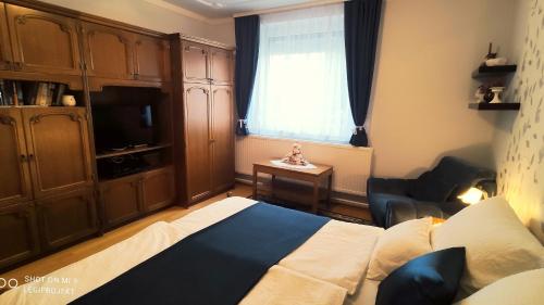 a bedroom with a bed and a tv and a window at Papp Apartmanház in Vonyarcvashegy