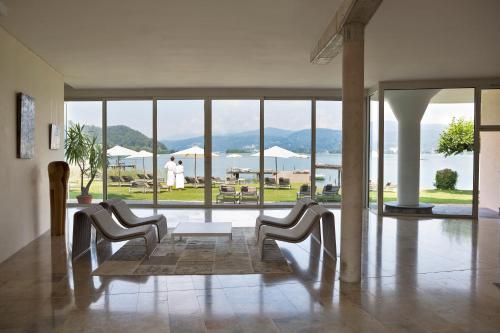 a living room with chairs and a view of the ocean at Hotel Linde in Maria Wörth