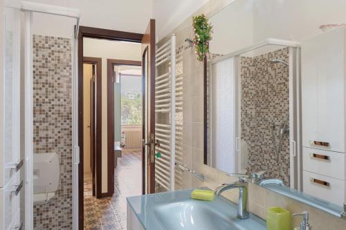 a bathroom with a sink and a mirror at GuestHost - Cadimare Lovely Apartment in La Spezia