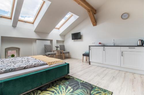 a bedroom with a bed and a kitchen with skylights at Dluga Apartments in Krakow