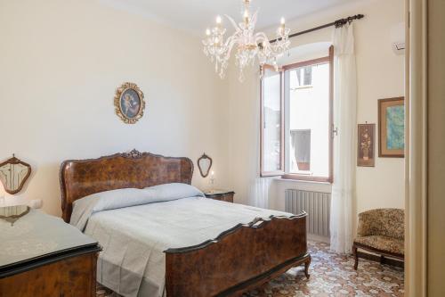 um quarto com uma cama e um lustre em Cadimare Lovely Apartment em La Spezia
