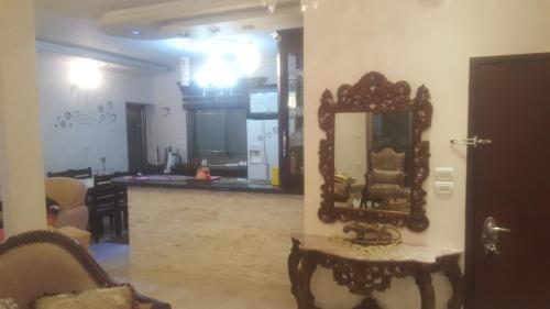 Nablus luxury Residence في نابلس: غرفة معيشة مع مرآة على الحائط