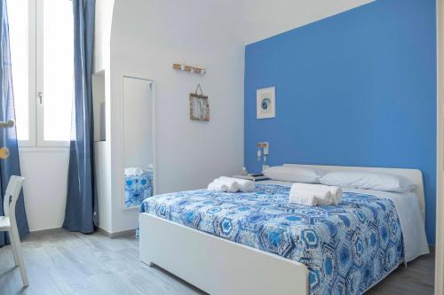 a blue bedroom with a bed with two towels on it at Il Pendio B&B in Bisceglie