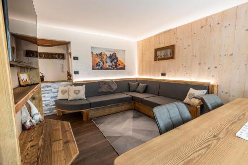 a living room with a couch and a table at Sa Mont Home - Moderno appartamento con giardino, sauna, barbecue in Bellamonte