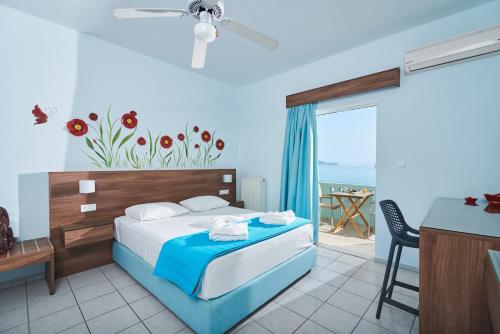 a bedroom with a bed and a balcony with the ocean at Aptera Beach in Amoudara Herakliou
