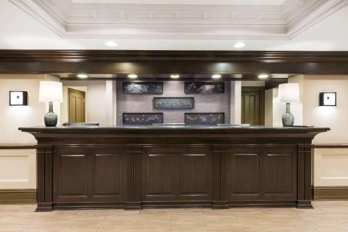 a large wooden bar in a lobby with two vases at Wyndham New Orleans French Quarter in New Orleans