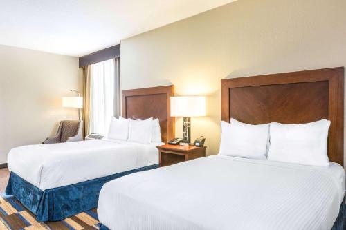 two beds in a hotel room with white sheets at Wyndham New Orleans French Quarter in New Orleans