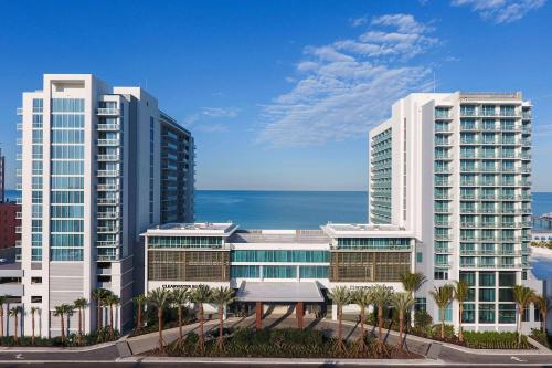 two tall buildings with palm trees in front of the ocean at Wyndham Grand Clearwater Beach in Clearwater Beach