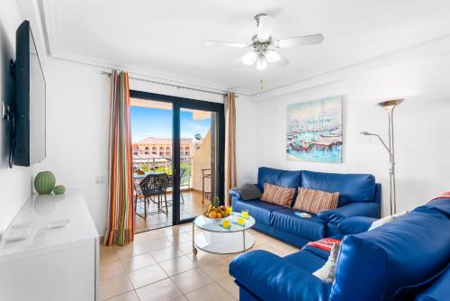 a living room with a blue couch and a table at Tenerife South Apartments in Playa de las Americas