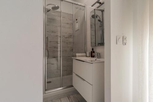 une salle de bain blanche avec une douche et un lavabo dans l'établissement Le Pitchoun, à Marseille