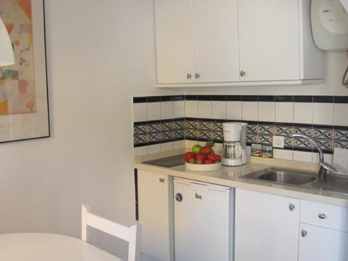 a kitchen with white cabinets and a bowl of fruit at Puerto De Mogan Harbour 371 in Puerto de Mogán