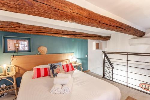 um quarto com uma cama com almofadas vermelhas e brancas em Le Cabanon du Vieux Port em Marselha