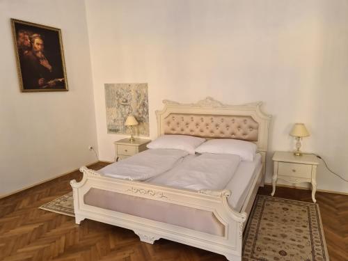 un letto bianco in una stanza con due tavoli di Apartmány Svätá Barborka a Banská Štiavnica