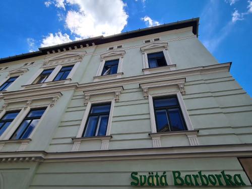 a white building with windows on top of it at Apartmány Svätá Barborka in Banská Štiavnica