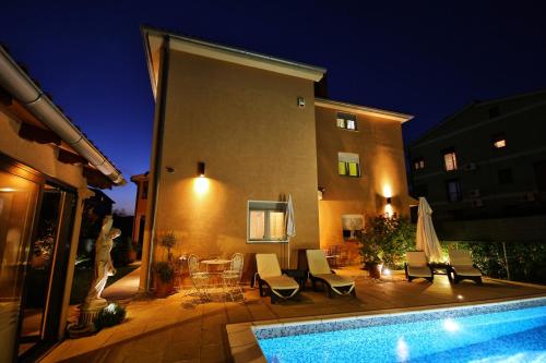 a backyard with a swimming pool and a house at Villa Mihaela in Fažana