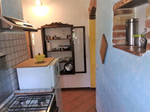 a kitchen with a stove and a refrigerator at Casa vacanze Sardegna " Tzia Maurissia " in Teulada