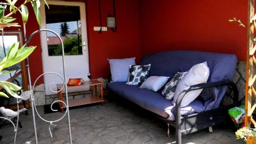 a blue couch in a room with a red wall at Papp Apartmanház in Vonyarcvashegy