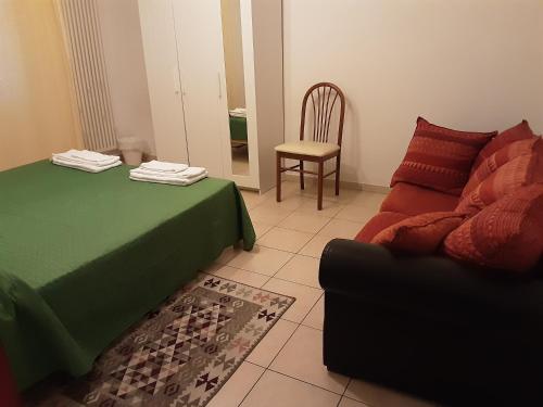 Habitación con cama, sofá y silla en Locazione Menini - Camere zona stazione, en Padua