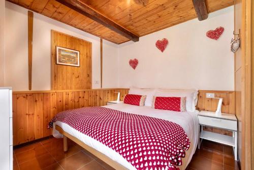 a bedroom with a bed with hearts on the wall at Chalet Casa dei Nonni in Ceppo Morelli