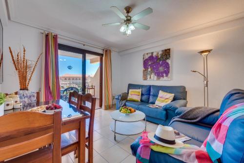a living room with a blue couch and a table at Tenerife South Apartments in Playa de las Americas