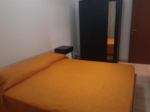 1 dormitorio con 1 cama con manta naranja en Locazione Menini - Camere zona stazione, en Padua
