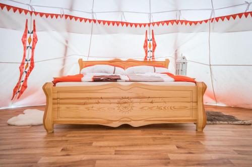 a bedroom with a wooden bed in a tent at Ranč pod Ostrou Skalou in Stratená