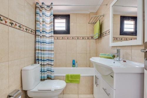 a bathroom with a toilet and a sink and a tub at Tenerife South Apartments in Playa de las Americas