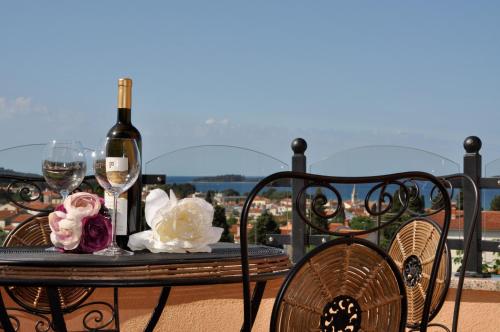 a table with a bottle of wine and two glasses at Villa Mihaela in Fažana