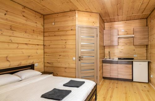 a bedroom with a bed in a wooden room at Sonyachni bungalo in Melʼniki