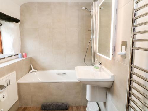 利斯卡德的住宿－Meadow Lea，浴室配有盥洗盆、浴缸和盥洗盆