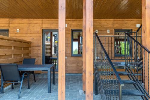 a wooden house with a table and chairs on a patio at Sonyachni bungalo in Melʼniki